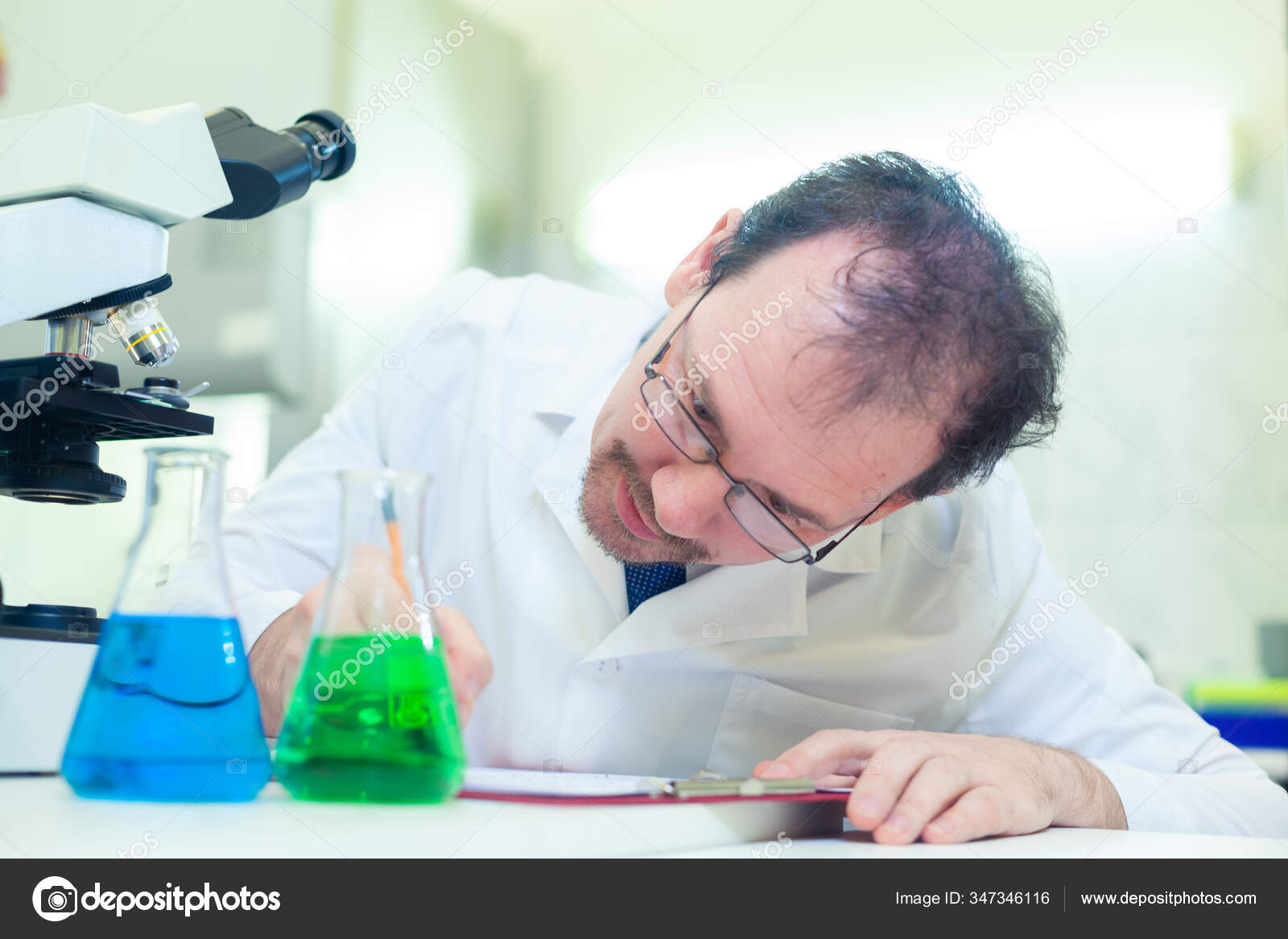 Chemist crazy. A mad scientist conducts experiments in a scientific  laboratory. Intently records the results of the study. — Stock Photo ©  satyrenko #347346116, image size:1600x1167