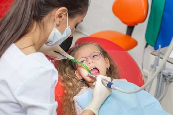 Un niño con un dentista en un consultorio dental . — Foto de Stock