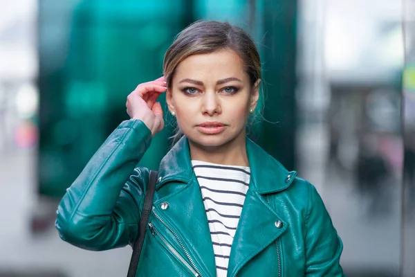 Outdoors lifestyle fashion portrait of stunning brunette girl. Walking on the city street. Going shopping. Dressed in a stylish turquoise green jacket. Close up. Business woman. — Stock Photo, Image