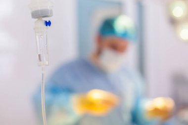 Hastanedeyiz. Cerrah ameliyathanede ameliyat yapar. Ameliyat doktorlarıyla bulanık bir geçmişi olan bir damlatıcı.