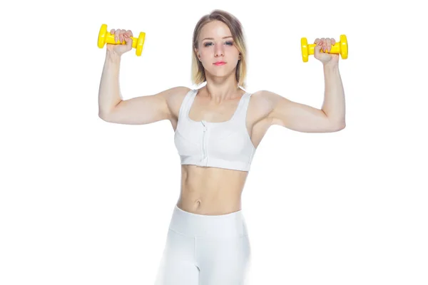 Mulher fitness trabalhando com halteres amarelos mostrando seus músculos no fundo branco — Fotografia de Stock