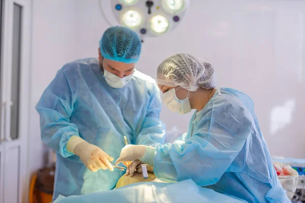 Do szpitala. Chirurg operuje na sali operacyjnej. Preparaty przed włożeniem implantu do powiększania piersi. — Zdjęcie stockowe