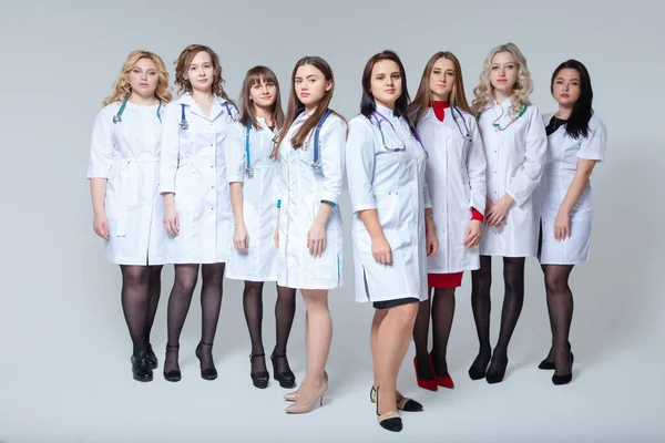 Feminism. Full length portrait of a successful group of doctors staying in front of grey background — Stock Photo, Image