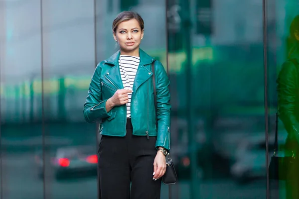 Buiten lifestyle modeportret van een prachtig brunette meisje. Wandelen op straat. Winkelen. Gekleed in een stijlvolle turquoise groene jas en zwarte broek. Zakelijke vrouw. — Stockfoto