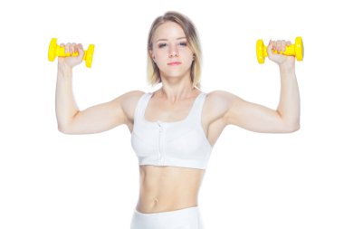 Spor salonundaki kadın sarı halterlerle çalışıyor. Beyaz arka planda kaslarını gösteriyor.