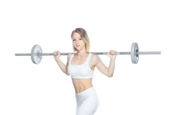 Красивая спортсменка накачивает мышцы штангой на белом фоне — стоковое фото