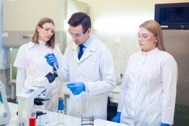 Bir grup bilim adamı ileri teknolojiyi kullanarak bir bilimsel laboratuvarda araştırma yapıyor. COVID-19. COVID Coronavirüs