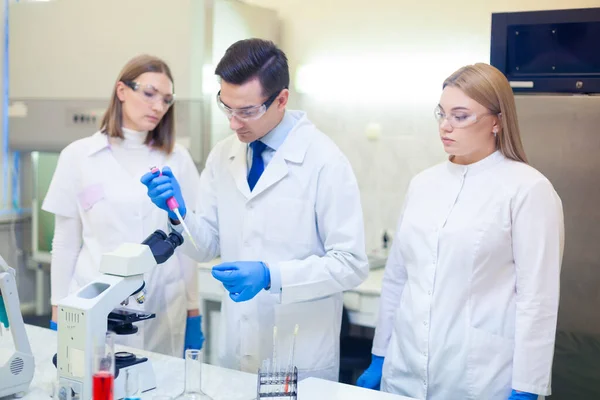 En grupp forskare bedriver forskning i ett vetenskapligt laboratorium med hjälp av avancerad teknik. COVID-19. COVID Coronavirus — Stockfoto