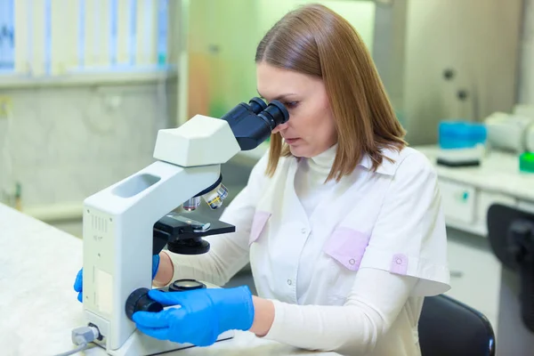 Laboratorieassistent som arbetar med mikroskop i ett vetenskapligt laboratorium. COVID-19. COVID Coronavirus — Stockfoto