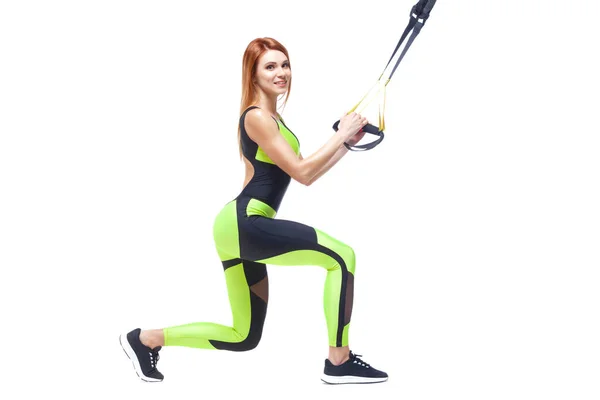 Jonge aantrekkelijke vrouw training met htrx fitness bandjes. Geïsoleerde witte achtergrond. Exemplaar-pasta. — Stockfoto