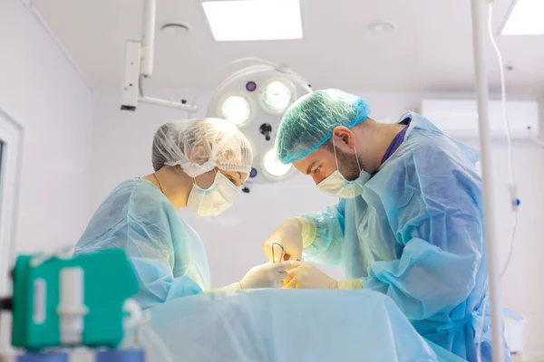 Al hospital. El cirujano opera en el quirófano. Cirujanos salvan la vida a los heridos . — Foto de Stock