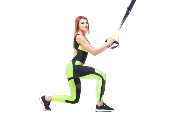 Young attractive woman training with trx fitness straps. Isolated white background — Stock Photo, Image