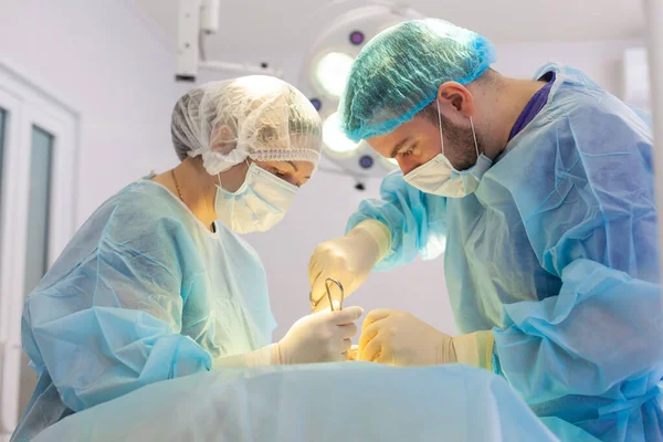 Hastanedeyiz. Cerrah ameliyathanede ameliyat yapar. Cerrahlar yaralılara hayat kurtarır. — Stok fotoğraf