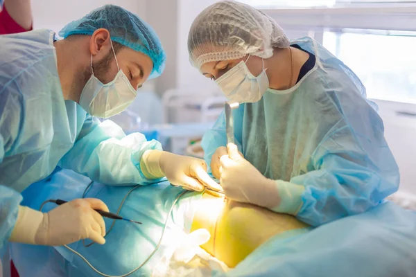 No hospital. O cirurgião opera na sala de operações. Preparações antes de inserir um implante num aumento da mama . — Fotografia de Stock