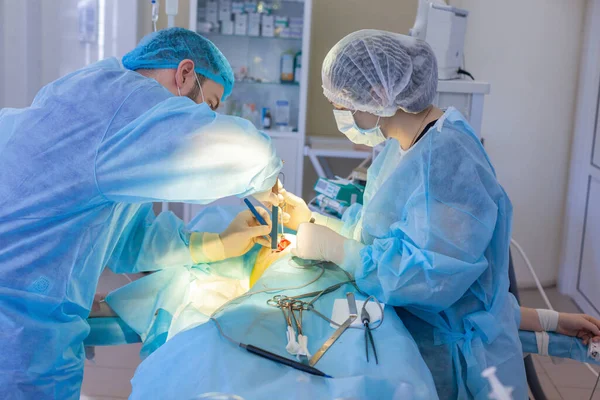Do szpitala. Chirurg operuje na sali operacyjnej. Chirurg rozpoczyna operację powiększenia piersi. — Zdjęcie stockowe