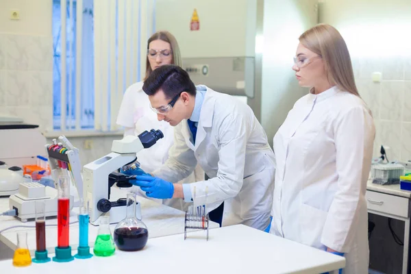 En grupp forskare bedriver forskning i ett vetenskapligt laboratorium med hjälp av avancerad teknik. COVID-19. COVID Coronavirus — Stockfoto