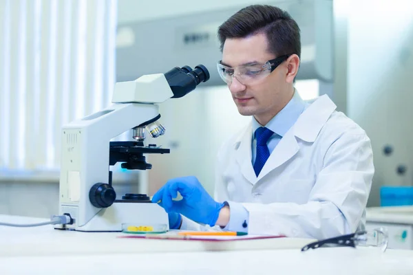 Los científicos estudian las propiedades y beneficios de los ácidos grasos omega 3 utilizando microscopio y equipo de laboratorio en un laboratorio médico. COVID-19. COVID Coronavirus —  Fotos de Stock