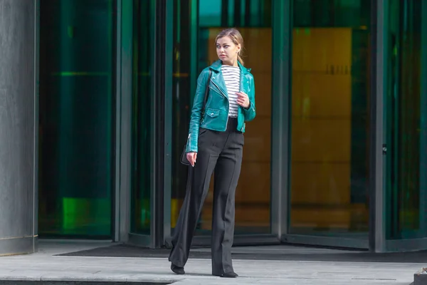 Vestido com uma elegante jaqueta verde turquesa e calças pretas . — Fotografia de Stock