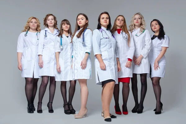Feminizm. Pełen portret udanej grupy lekarzy przebywających na szarym tle — Zdjęcie stockowe