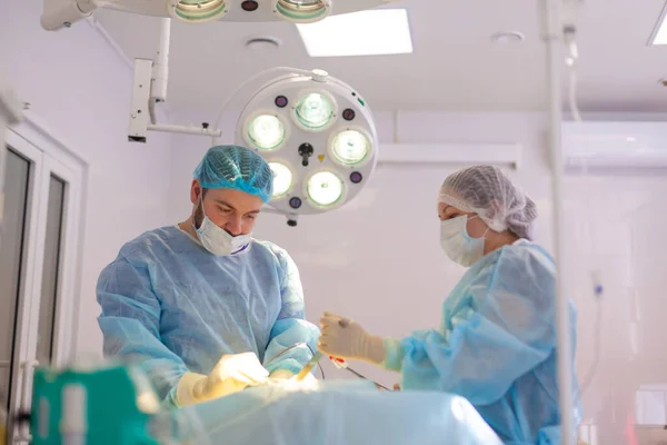 Do szpitala. Chirurg operuje na sali operacyjnej. Lekarze robią wszystko, co możliwe, aby leczyć pacjenta po wypadku.. — Zdjęcie stockowe