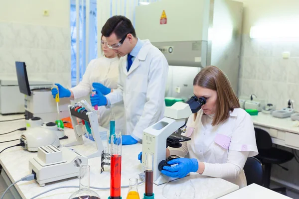 Un grupo de científicos lleva a cabo investigaciones en un laboratorio científico utilizando tecnología avanzada. COVID-19. COVID Coronavirus —  Fotos de Stock