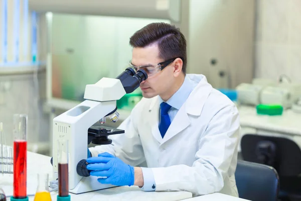 Forskaren forskar i mikroskop i ett medicinskt laboratorium. COVID-19. COVID Coronavirus — Stockfoto