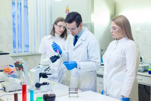 En grupp forskare bedriver forskning i ett vetenskapligt laboratorium med hjälp av avancerad teknik. COVID-19. COVID Coronavirus — Stockfoto