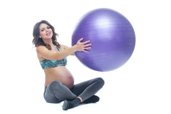 Portréja egy szép fiatal terhes nő gyakorolja a fitball. Munka-és fitness, terhességi koncepció. Elszigetelt fehér háttér. — Stock Fotó