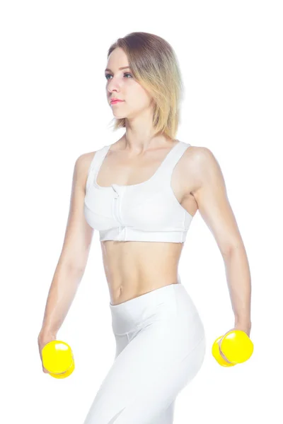 Mujer fitness haciendo ejercicio con pesas amarillas mostrando sus músculos sobre fondo blanco —  Fotos de Stock