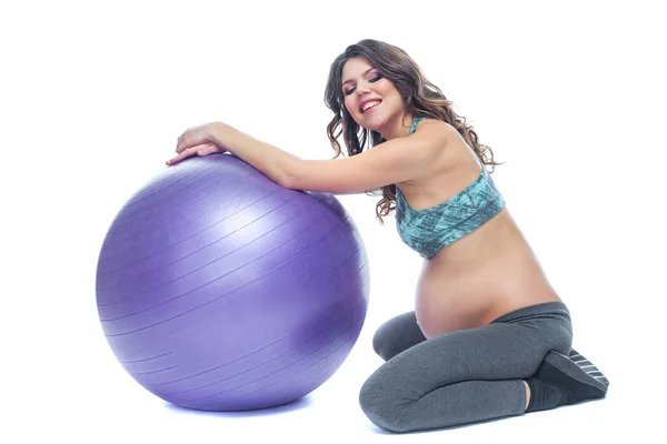 Portret van een mooie jonge zwangere vrouw oefeningen met fitball. Trainen en fitness, zwangerschaps concept. Geïsoleerde witte achtergrond. — Stockfoto