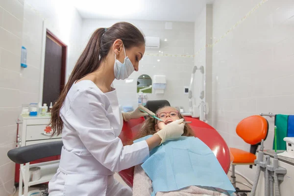 Un bambino con un dentista in uno studio dentistico . — Foto Stock