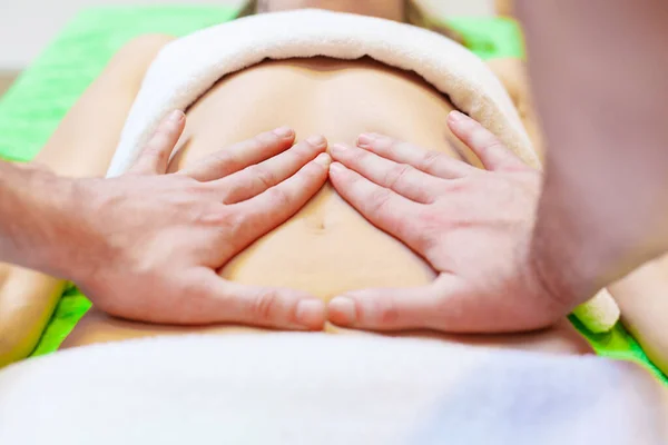 Ovanifrån av händer massera kvinnlig buk. Terapeut sätter tryck på magen. Kvinna som får massage på spa salong — Stockfoto