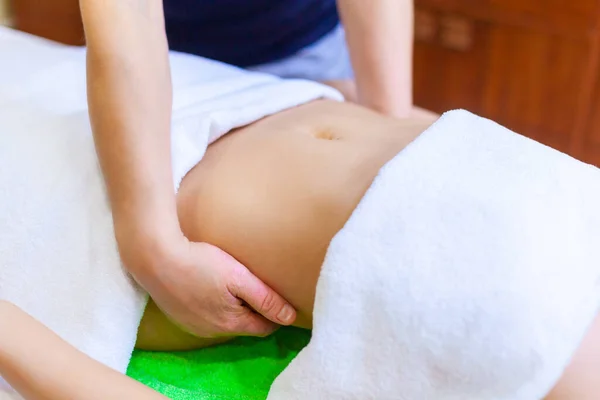 Widok dłoni masujących kobiecy brzuch. Kobieta otrzymująca masaż w salonie spa — Zdjęcie stockowe
