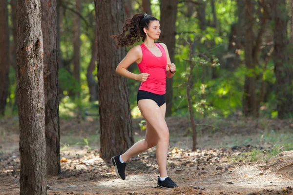 Young woman runner training alone outdoors in the summer forest — Stock Photo, Image