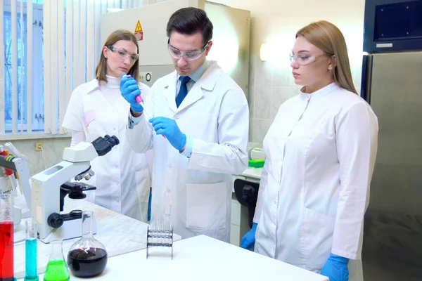 Un grupo de científicos realiza investigaciones en un laboratorio científico — Foto de Stock