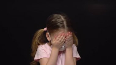 Coronavirus ve Hava kirliliği konsepti. Korunmak için maske takan küçük kız. Wuhan Coronavirus ve salgın virüs belirtileri. Ağlıyor ve COVID-19 'dan korkuyor. Siyah bir arkaplanda izole edilmiş.