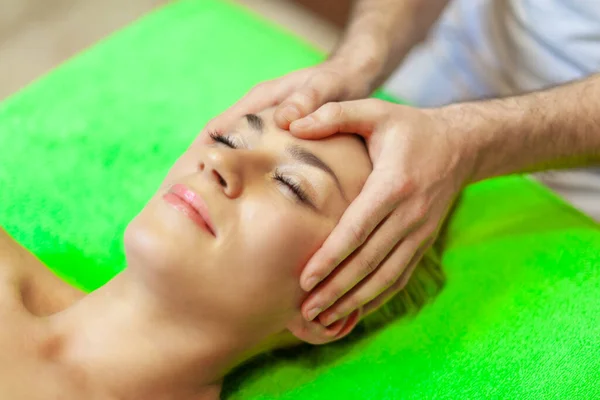 Close up de bela jovem relaxante com massagem facial no spa de beleza — Fotografia de Stock