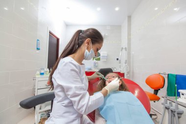 Diş hekimi diş bir ofiste bir çocukla.