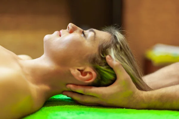 Vista lateral cercana de la hermosa mujer joven relajándose con masaje en la cabeza en el spa de belleza —  Fotos de Stock