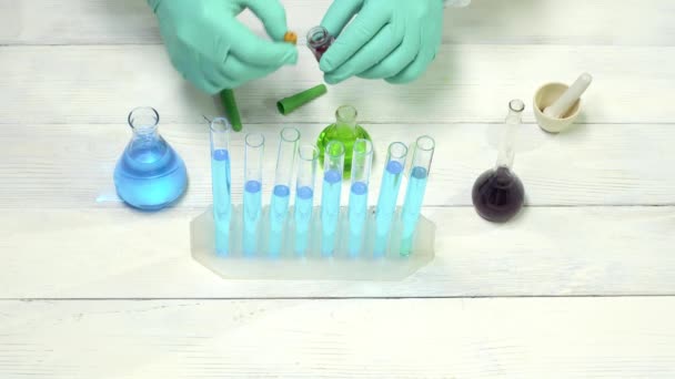 Scientist dropping the reagent into test tube for reaction testing in chemical laboratory. — Stock Video