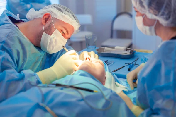 Le chirurgien s'est penché sur le patient pendant l'opération. Un groupe de chirurgiens travaille dans la salle d'opération — Photo