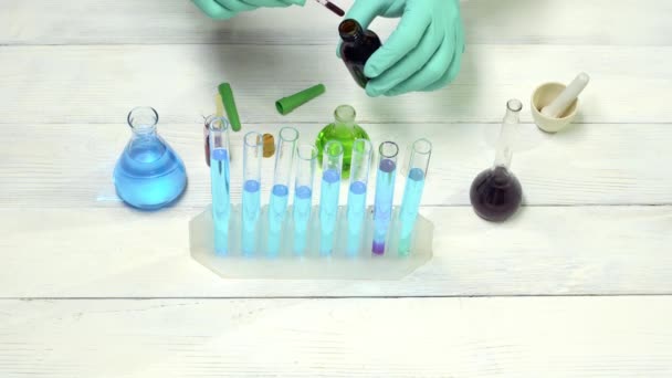 Scientifique jetant le réactif dans une éprouvette pour des essais de réaction en laboratoire chimique . — Video