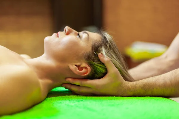 Vue latérale rapprochée de la belle jeune femme relaxante avec massage de la tête au spa de beauté — Photo