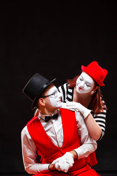 Portrait of two mime artists, isolated on black background. Woman and man look at each other with love. Symbol of happy marriage, sweet couple, family