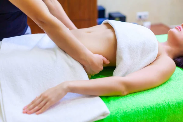 Vue du dessus des mains massant l'abdomen féminin. Femme recevant un massage au salon de spa — Photo