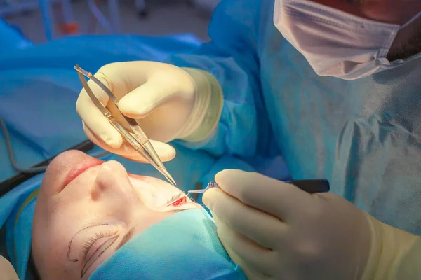 Der Chirurg nimmt während der Blepharoplastik einen Schnitt am Augenlid des Patienten vor. Nahaufnahme — Stockfoto