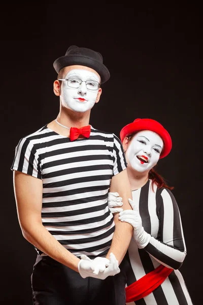 Portrait of two mime artists performing, isolated on black background. Man is standing straight and woman nestled against him. Symbol of warm relationships, friendship, trust — Stock Photo, Image