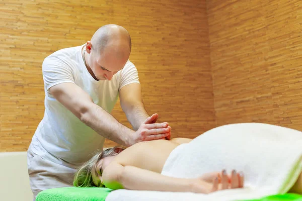 Foto de massagista realizando massagem tailandesa tradicional na mulher de volta no salão de spa. Conceito de tratamento de beleza — Fotografia de Stock