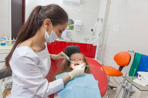 Uma criança com um dentista em um consultório odontológico . — Fotografia de Stock