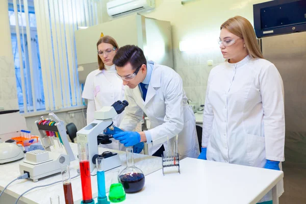 En grupp forskare bedriver forskning i ett vetenskapligt laboratorium med hjälp av avancerad teknik. COVID-19. COVID Coronavirus — Stockfoto